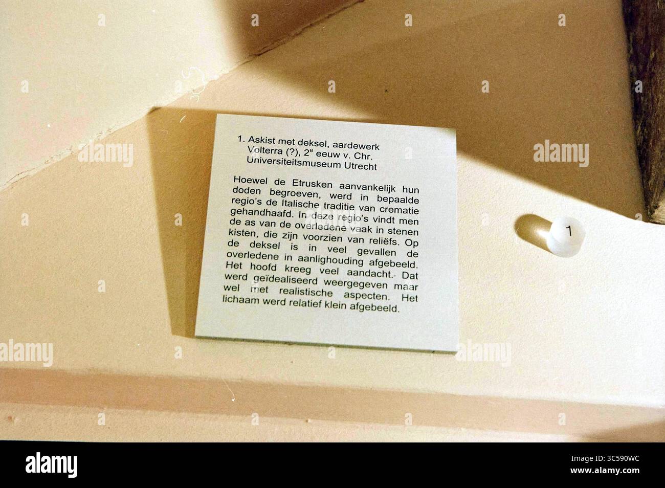 Museo archeologico Haarlem., Haarlem, Paesi Bassi, 14-02-2002 Whizgle News, Dutch Desk, i Paesi Bassi, 1950-2000 Un'etichetta espositiva che spiega un manufatto legato agli Etruschi, evidenziando la loro prospettiva sulle regioni e le pratiche culturali, nonché il significato dell'oggetto in relazione alla società etrusca. Foto Stock