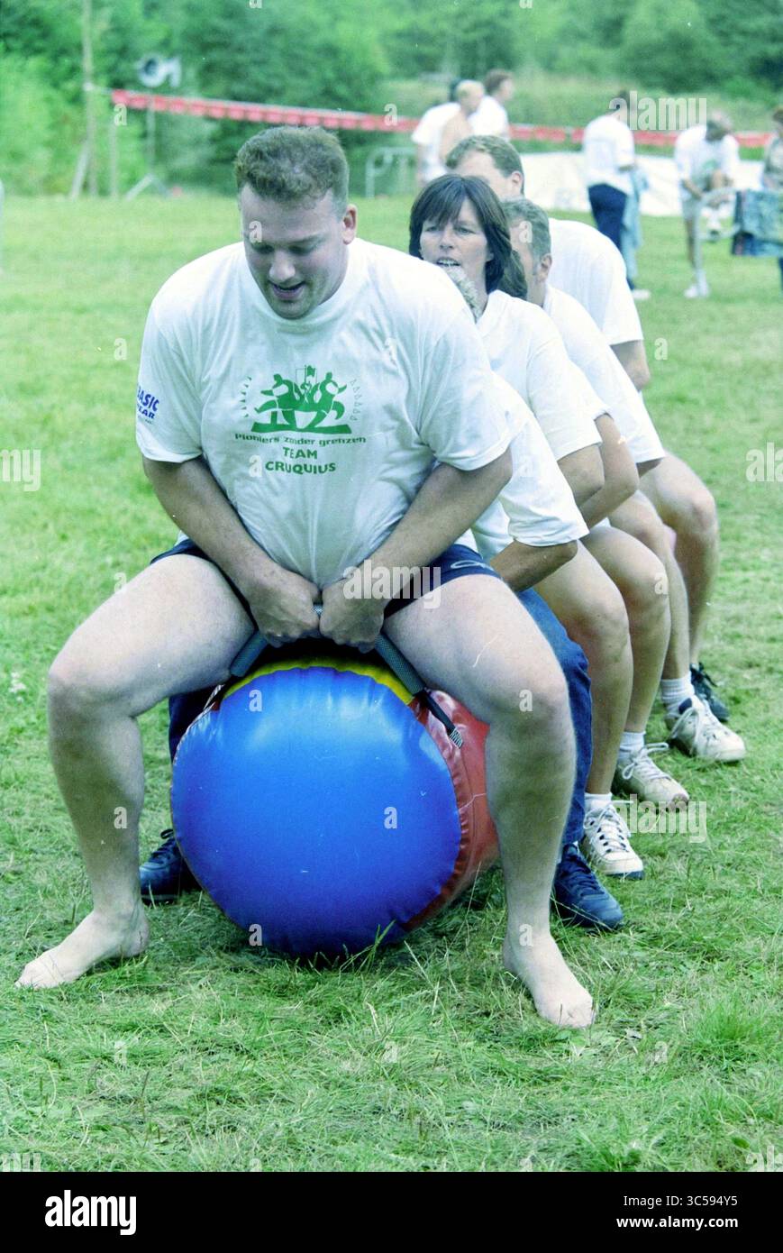 Game Without Borders, Hoofddorp, Paesi Bassi, 29-08-2003 Whizgle News, Dutch Desk, i Paesi Bassi, 1950-2000 partecipanti sono impegnati in una divertente attività di squadra all'aperto, bilanciandosi su palloni gonfiabili colorati mentre lavorano insieme in una gara giocosa. Risate e cameratismo riempiono l'aria mentre navigano lungo il corso. Foto Stock