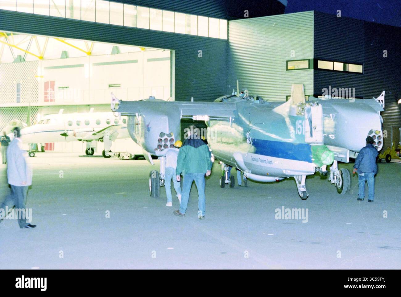 Traino di aeromobili presso NLC, Hoofddorp, Paesi Bassi, 01-07-1998 Whizgle News, Dutch Desk, i Paesi Bassi, 1950-2000 un aereo è in fase di preparazione per il decollo fuori da un hangar, con diversi individui visibili nelle vicinanze, impegnati in varie attività. La scena cattura l'atmosfera vivace di una struttura di aviazione al tramonto. Foto Stock