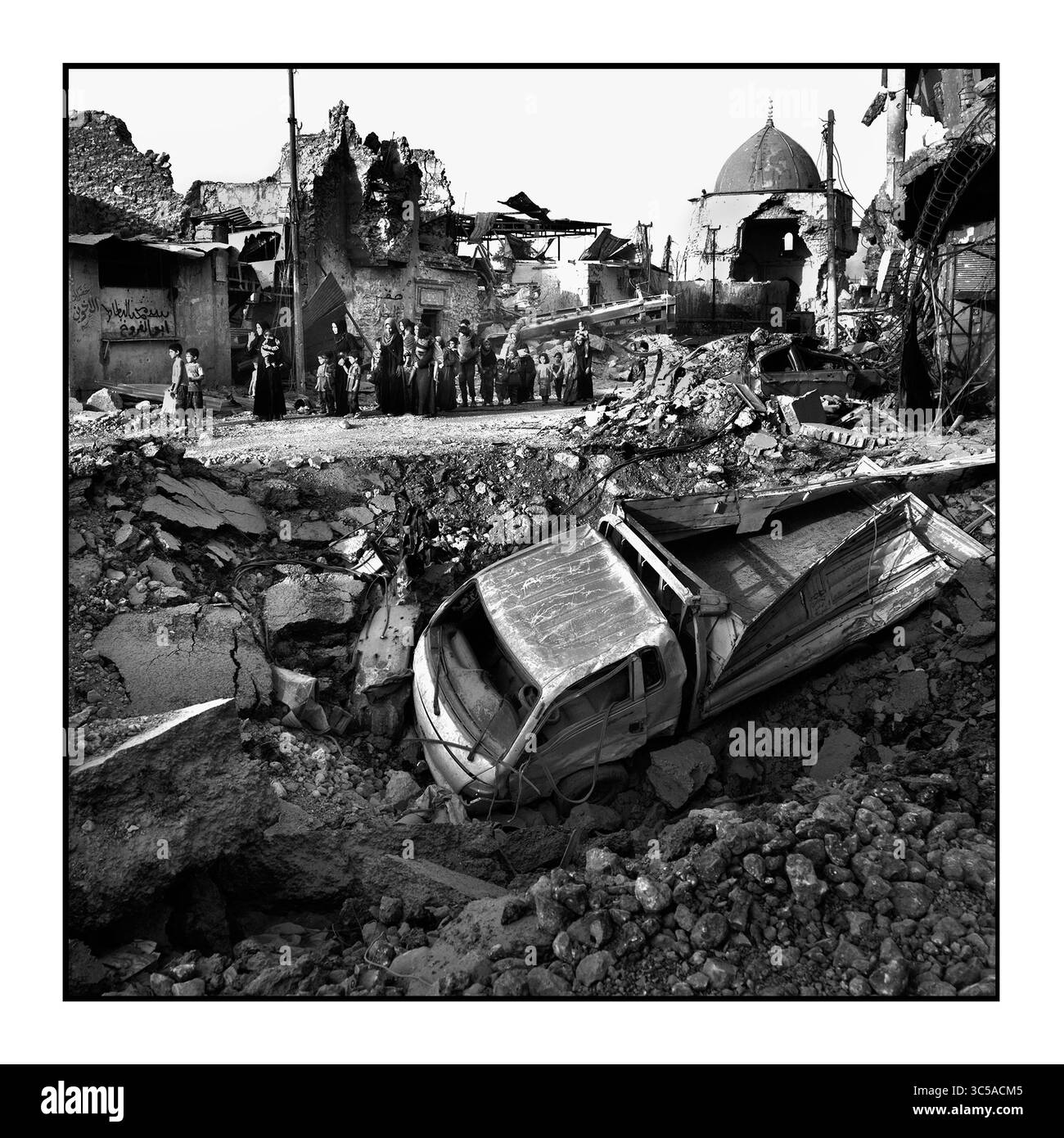 7 luglio 2017 - Mosul, Iraq - civili, molti feriti e deboli, passano davanti all'antica moschea distrutta dall'ISIS mentre fuggono dalla battaglia a West Mosul tra le rovine della città Vecchia. (Immagine di credito: © Carol Guzy/zReportage.com/ZUMA Wire) Foto Stock