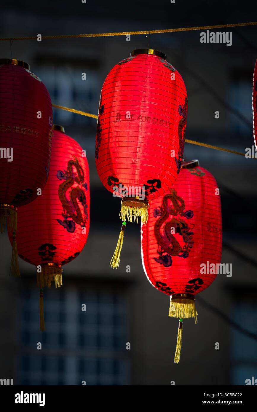 Primo piano di tradizionali lanterne rosse cinesi appese nella Chinatown di Londra, splendidamente illuminate con intricati disegni di draghi durante il Capodanno cinese Foto Stock