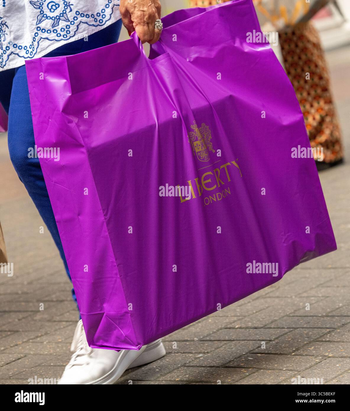 Primo piano di una shopping bag Liberty London portata da un acquirente a Soho, Londra, Regno Unito. Foto Stock