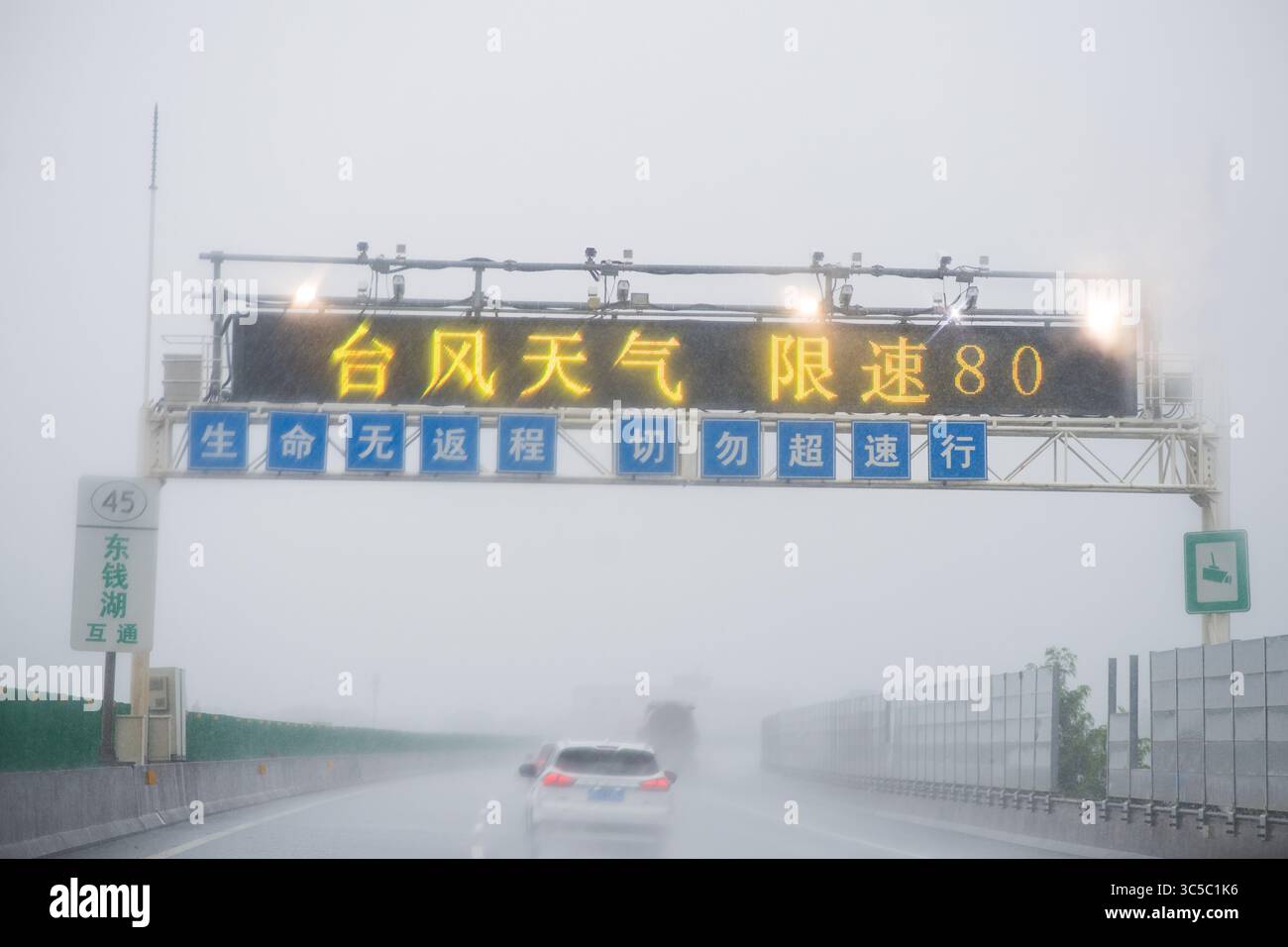 Zhoushan. 30 luglio 2025. Il limite di velocità è imposto su alcune autostrade, mentre il tifone Co-May approda nella provincia di Zhejiang nella Cina orientale il 30 luglio 2025. Co-May, l'ottavo tifone di quest'anno, ha sbarcato nella provincia di Zhejiang della Cina orientale intorno alle 4:30 di mercoledì, secondo l'osservatorio meteorologico provinciale. Il tifone, con la forza massima del vento vicino al suo centro che raggiunge i 23 metri al secondo, sbarcò a Zhoushan City di Zhejiang. Crediti: Jiang Han/Xinhua/Alamy Live News Foto Stock