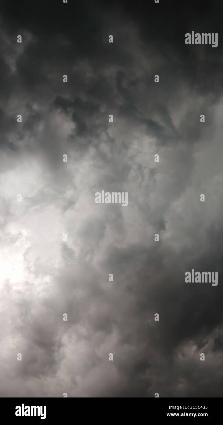 Nuvole di tempesta scure che si radunano nel cielo, creando un'atmosfera drammatica e lunare prima di un temporale. Foto Stock