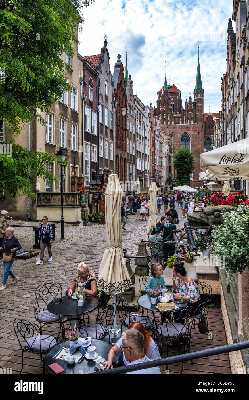 DANZICA, POLONIA - 3 SETTEMBRE 2023: Turisti e gente del posto siedono nei caffè all'aperto della storica Ulica Mariacka (via Santa Maria) nella città vecchia, con Foto Stock