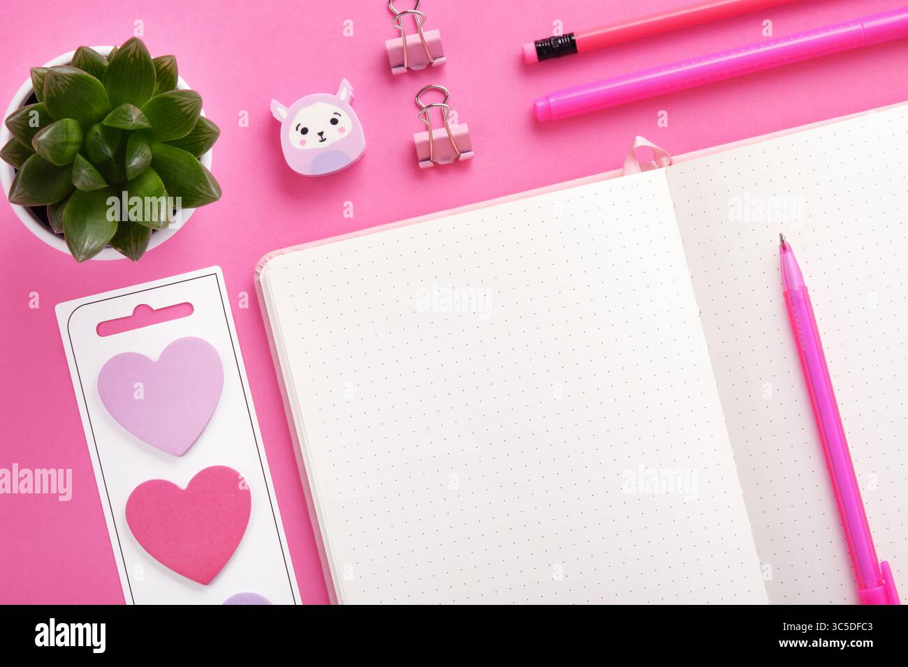 Pezzo di pagina vuota del notebook per il testo in una cornice di cancelleria di colore rosa. Adesivi a forma di cuore Foto Stock