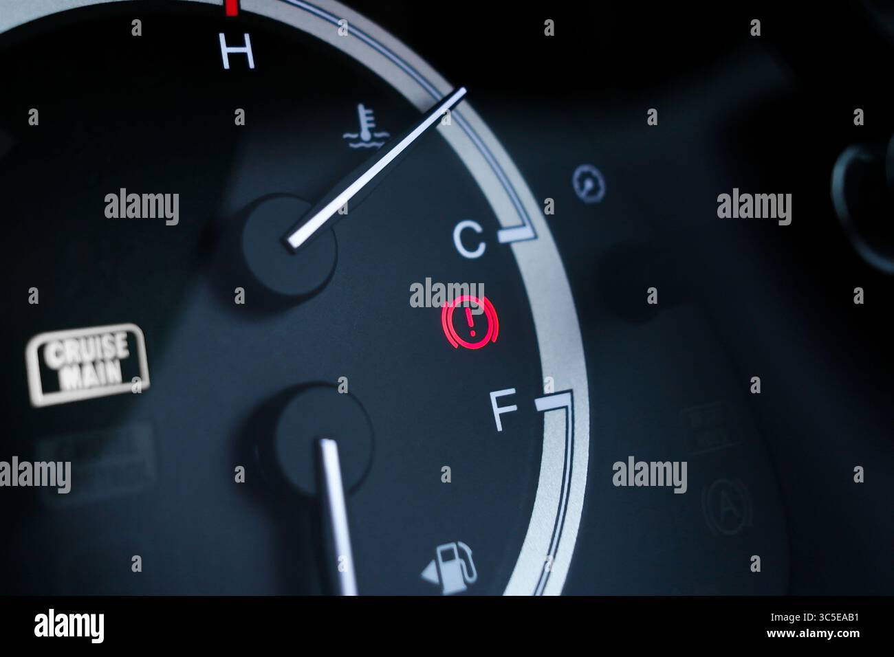 Spia rossa dell'impianto freni sul cruscotto dell'auto accanto agli indicatori di livello carburante e temperatura. Foto Stock