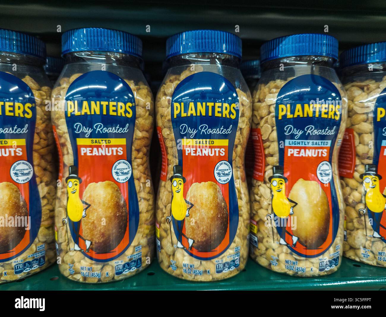 Fioriere arachidi tostate a secco perfettamente allineate sul ripiano della corsia dello snack del negozio di alimentari Foto Stock