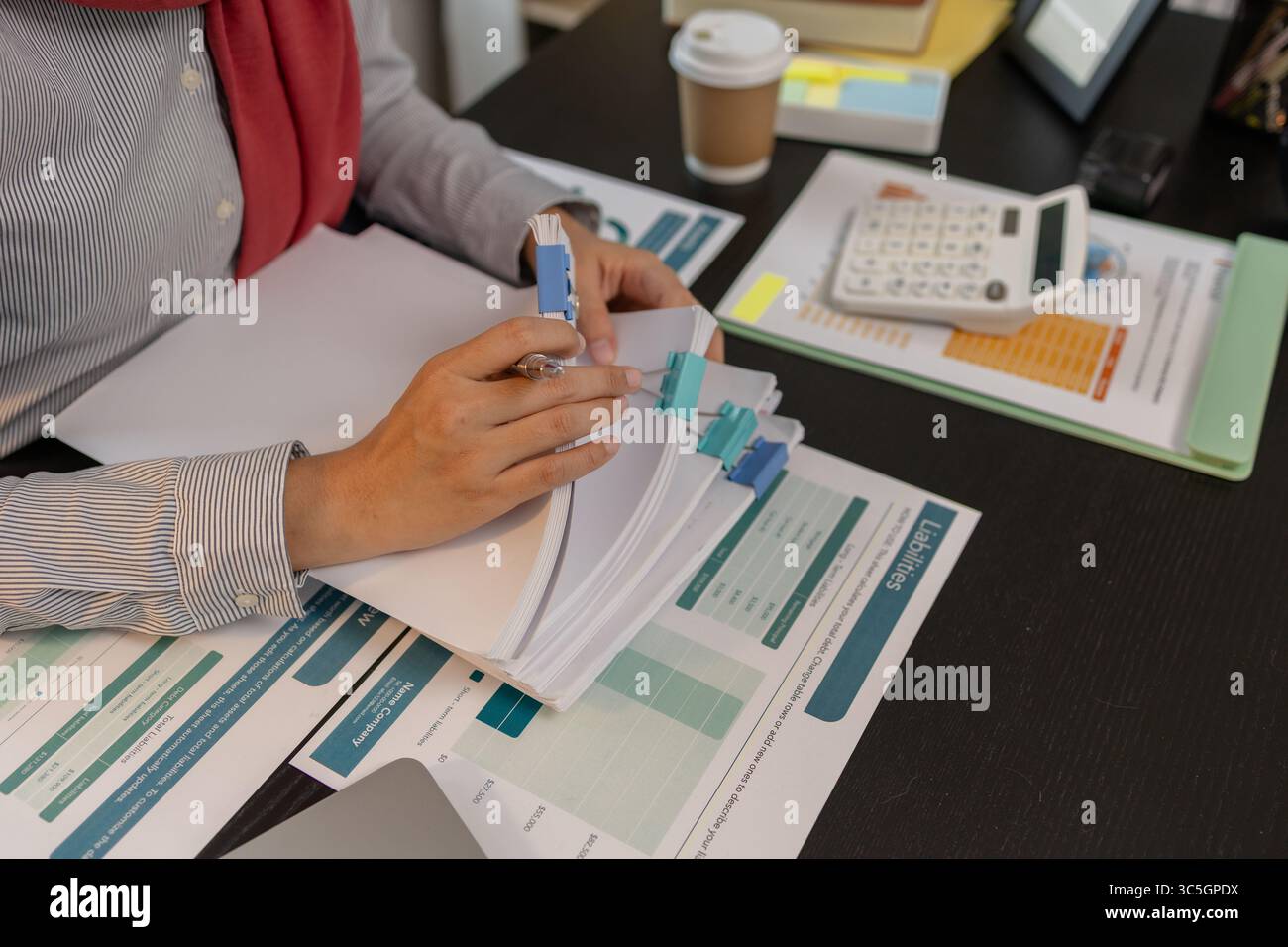 una dipendente di un'azienda musulmana lavora in una grande organizzazione finanziaria, una donna imprenditrice musulmana sta esaminando i documenti finanziari della sua azienda, il mercato Foto Stock