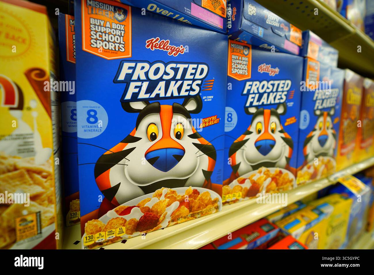 Scatole di cereali con fiocchi smerigliati esposte in modo impeccabile sullo scaffale del negozio di alimentari con l'iconico Tony the Tiger Foto Stock