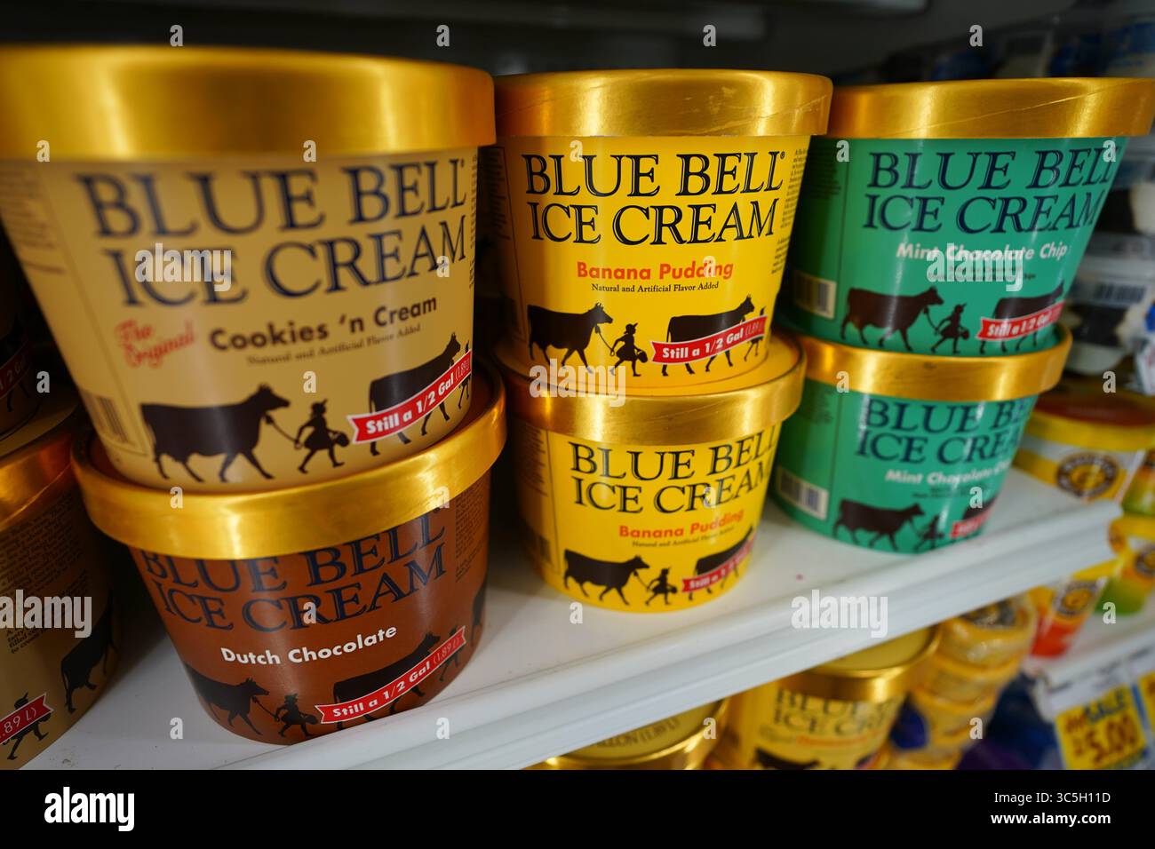 Prodotti da dessert Blue Bell Ice Cream perfettamente allineati sullo scaffale del negozio di alimentari con sapori diversi Foto Stock