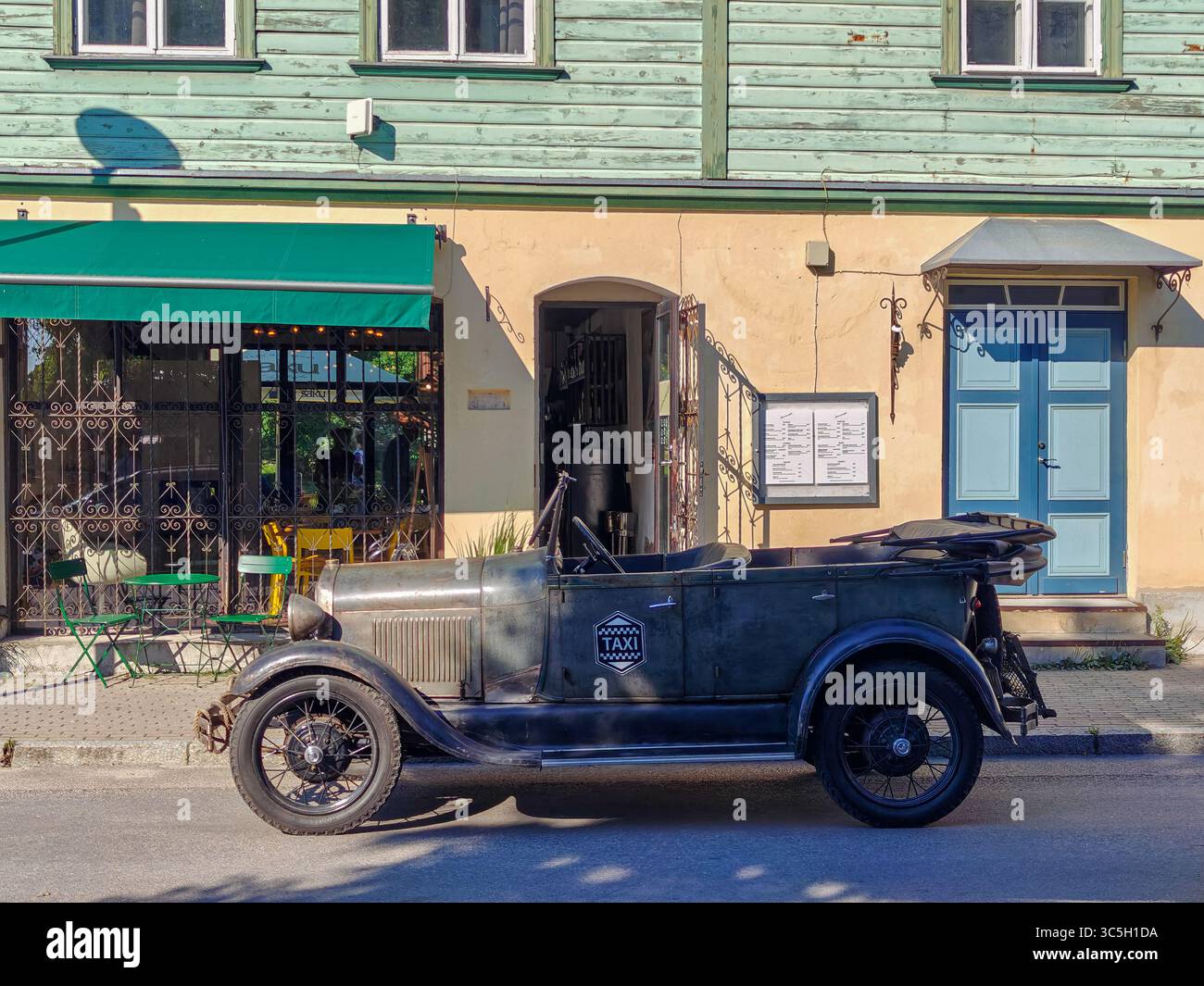 Taxi d'epoca parcheggiato di fronte a un affascinante edificio, che evoca un senso di nostalgia ed eleganza classica. Foto Stock