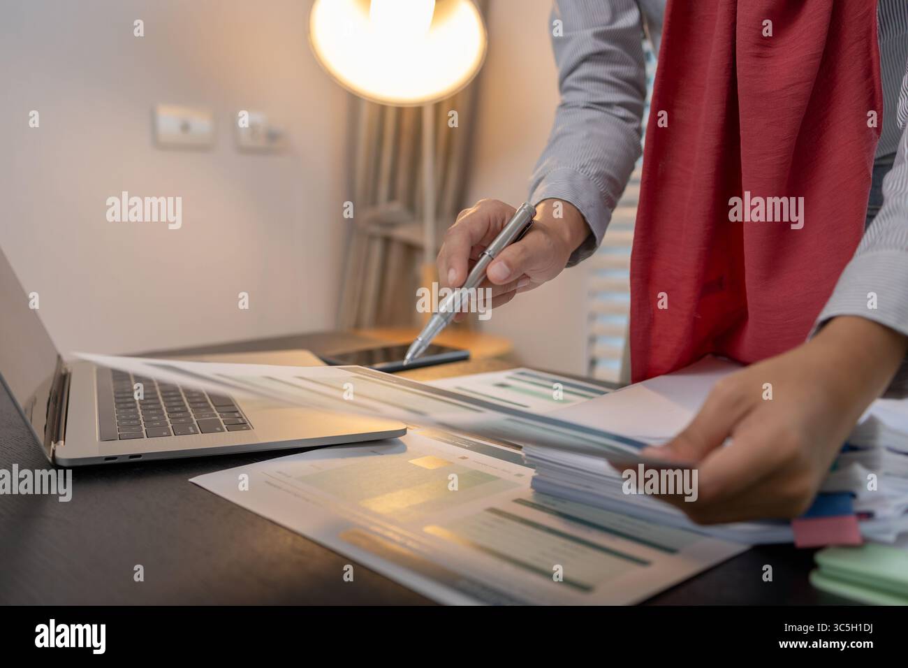 una donna imprenditrice musulmana sta esaminando i documenti finanziari della sua azienda, il marketing, il contabile, l'hijab, l'islam, un dipendente di un'azienda musulmana lavora in una Foto Stock