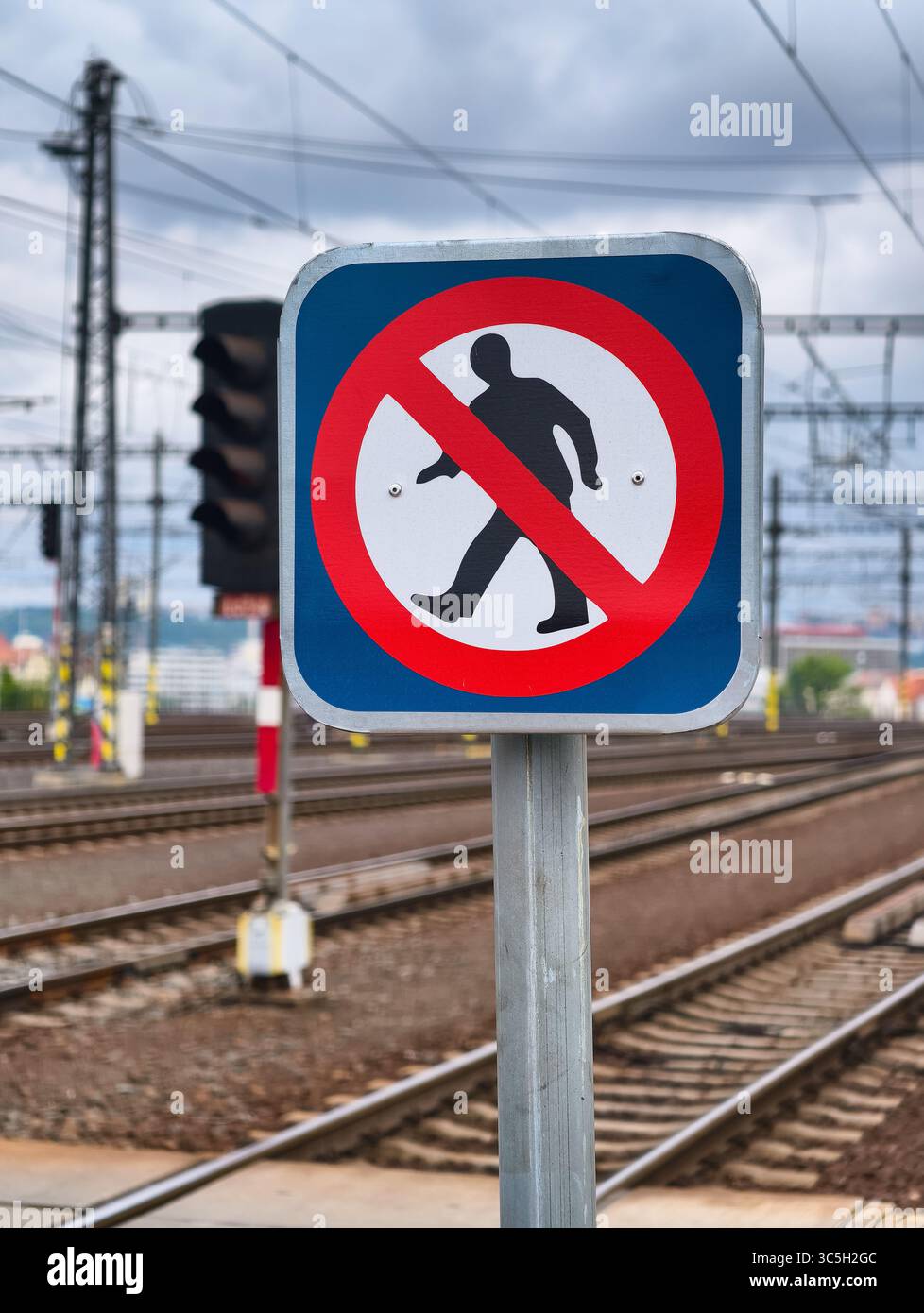 Cartello di avvertimento per la ferrovia di Trespassing. Binari per treni urbani ad alta risoluzione con cavi sospesi e luce di segnalazione rossa, sfondo astratto per sfondo, Web Design e Digital Media Foto Stock