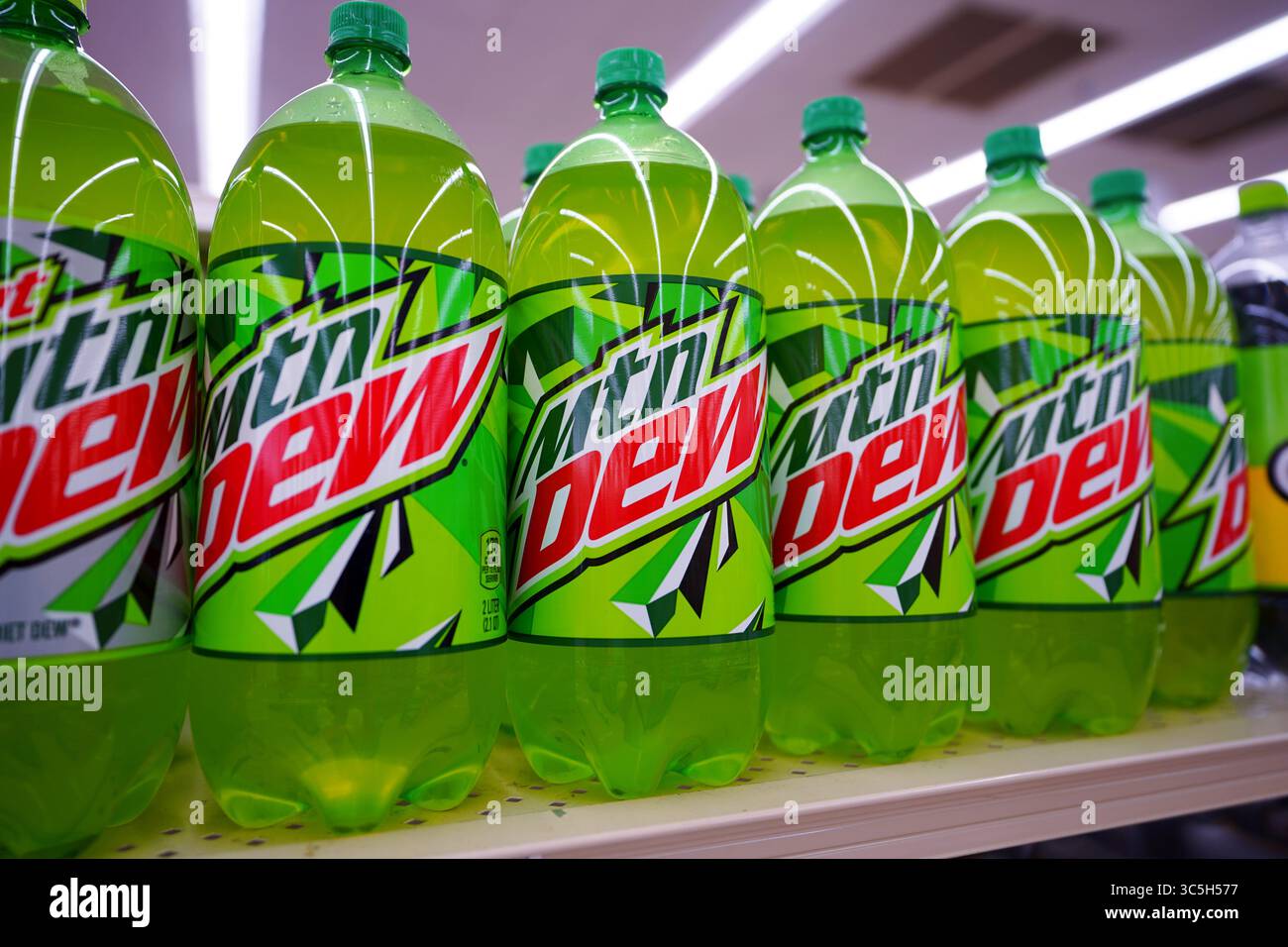 Bottiglie di bibite gassate Mountain Dew di varie dimensioni disposte in modo ordinato sullo scaffale del punto vendita Foto Stock