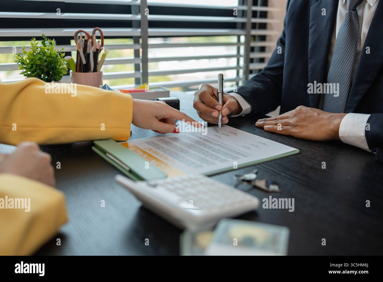 un agente immobiliare sta spiegando i dettagli di un contratto di acquisto di una casa a un acquirente, gli sta dicendo che si tratta di un investimento, di un bene immobile, Foto Stock