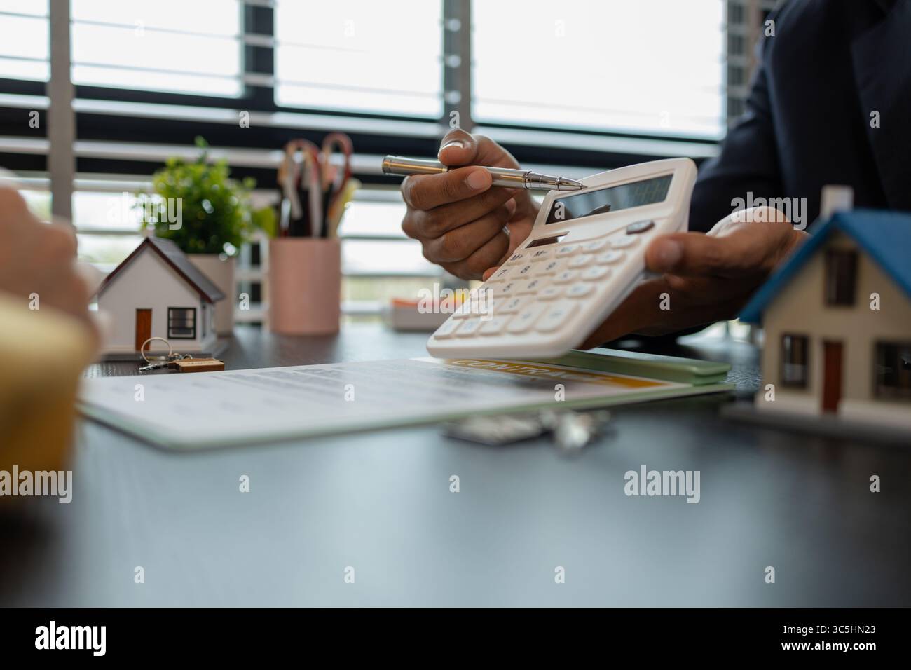 un agente immobiliare sta spiegando i dettagli di un contratto di acquisto di una casa a un acquirente, gli sta dicendo che si tratta di un investimento, di un bene immobile, Foto Stock