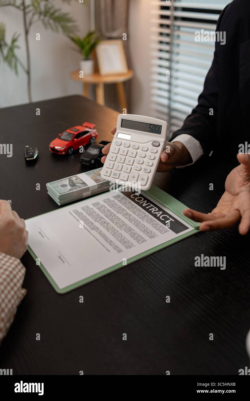 un venditore di auto sta spiegando i dettagli di una vettura e il prezzo a cui un acquirente è interessato, il responsabile vendite dello showroom ha spiegato la quantità di int Foto Stock