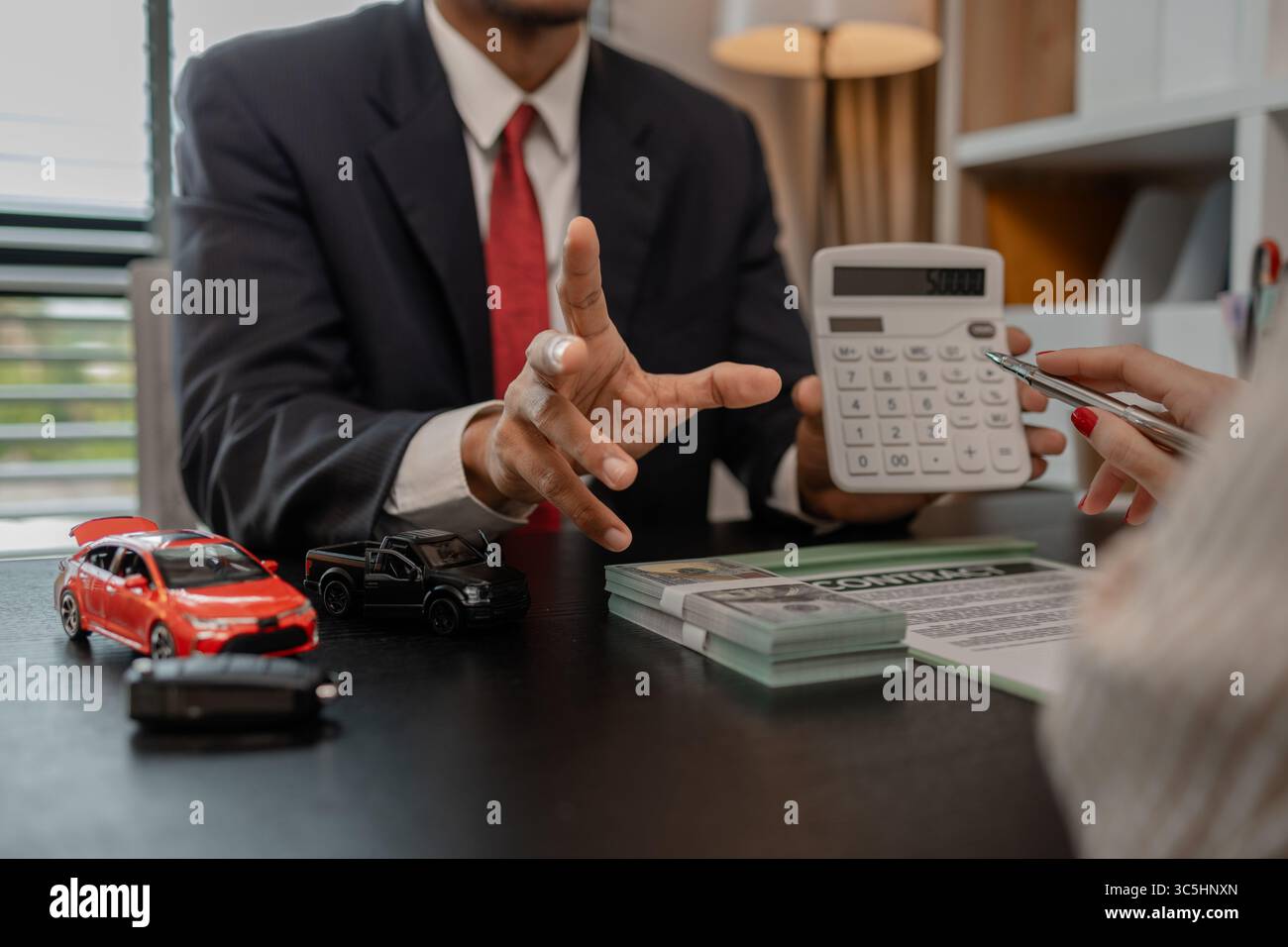 un venditore di auto sta spiegando i dettagli di una vettura e il prezzo a cui un acquirente è interessato, il responsabile vendite dello showroom ha spiegato la quantità di int Foto Stock