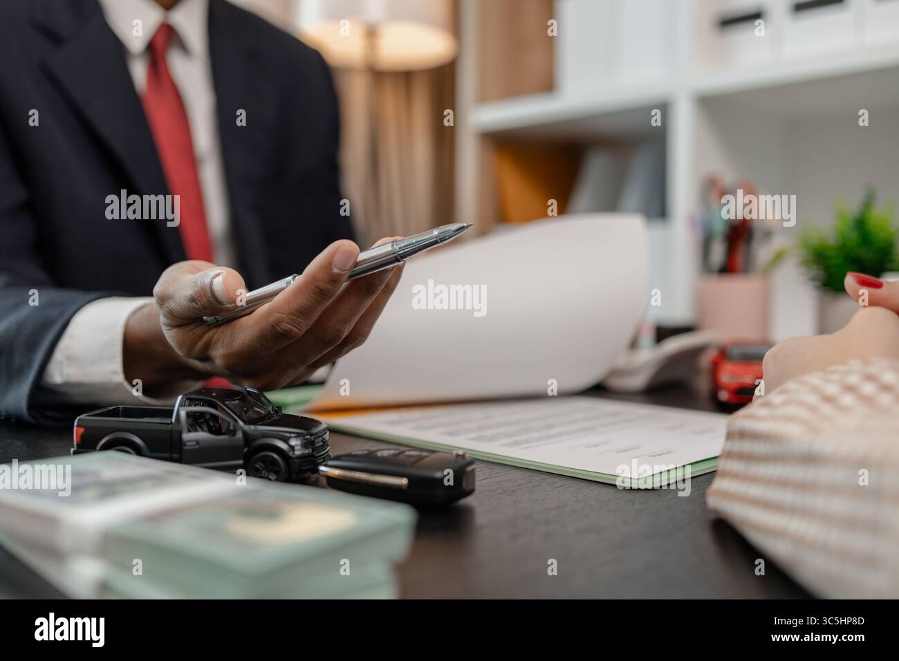 un venditore di auto sta spiegando i dettagli di una vettura e il prezzo a cui un acquirente è interessato, il responsabile vendite dello showroom ha spiegato la quantità di int Foto Stock