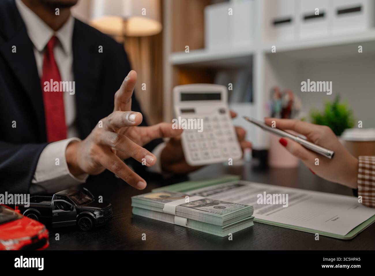 un venditore di auto sta spiegando i dettagli di una vettura e il prezzo a cui un acquirente è interessato, il responsabile vendite dello showroom ha spiegato la quantità di int Foto Stock