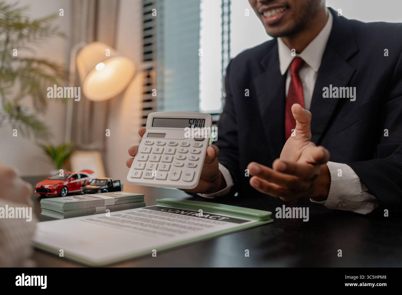 un venditore di auto sta spiegando i dettagli di una vettura e il prezzo a cui un acquirente è interessato, il responsabile vendite dello showroom ha spiegato la quantità di int Foto Stock