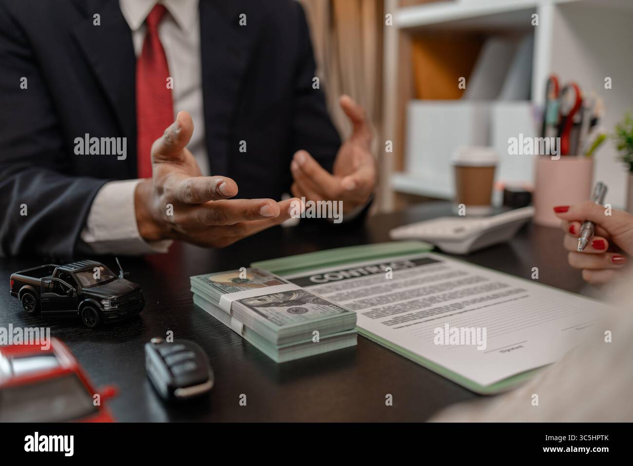 un venditore di auto sta spiegando i dettagli di una vettura e il prezzo a cui un acquirente è interessato, il responsabile vendite dello showroom ha spiegato la quantità di int Foto Stock