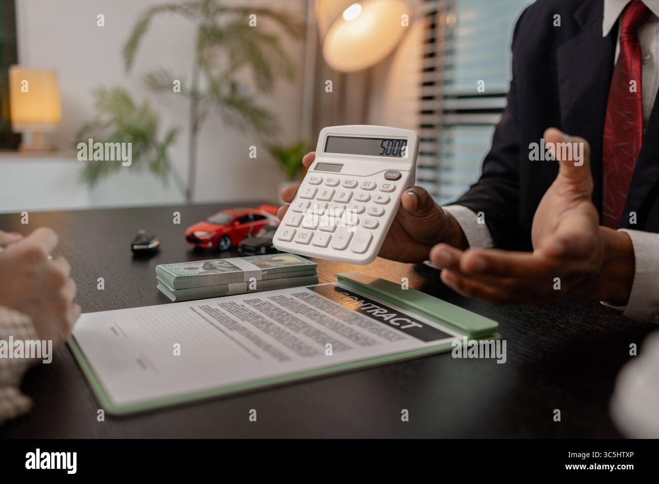 un venditore di auto sta spiegando i dettagli di una vettura e il prezzo a cui un acquirente è interessato, il responsabile vendite dello showroom ha spiegato la quantità di int Foto Stock