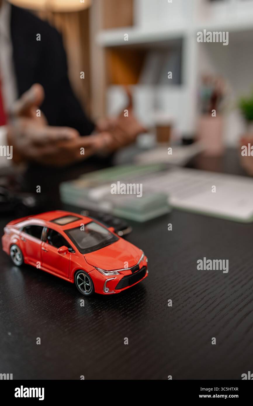 un venditore di auto sta spiegando i dettagli di una vettura e il prezzo a cui un acquirente è interessato, il responsabile vendite dello showroom ha spiegato la quantità di int Foto Stock