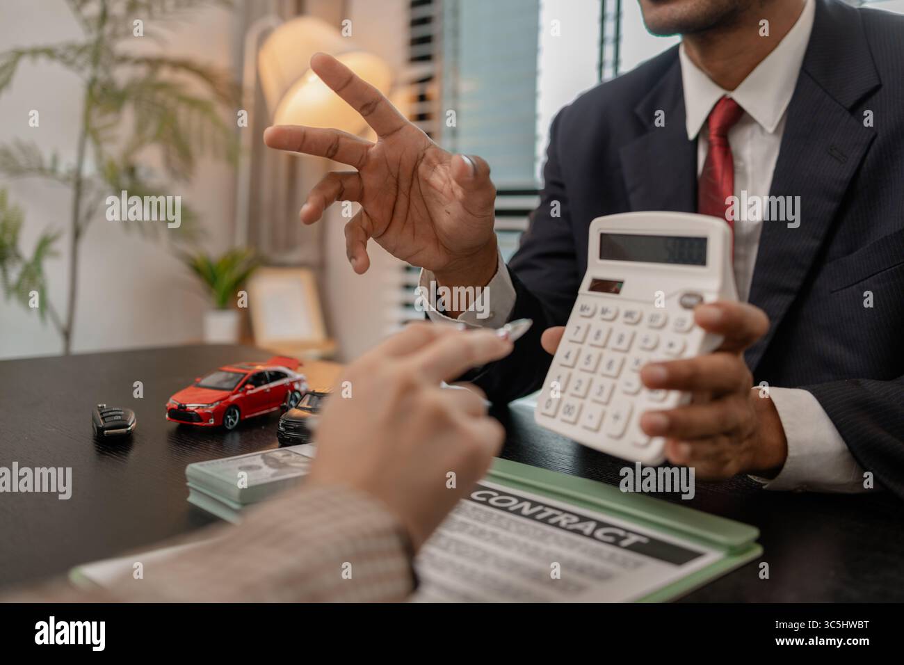 un venditore di auto sta spiegando i dettagli di una vettura e il prezzo a cui un acquirente è interessato, il responsabile vendite dello showroom ha spiegato la quantità di int Foto Stock