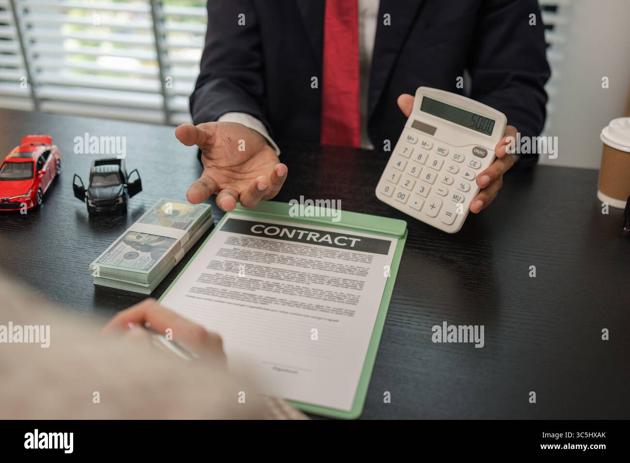 un venditore di auto sta spiegando i dettagli di una vettura e il prezzo a cui un acquirente è interessato, il responsabile vendite dello showroom ha spiegato la quantità di int Foto Stock