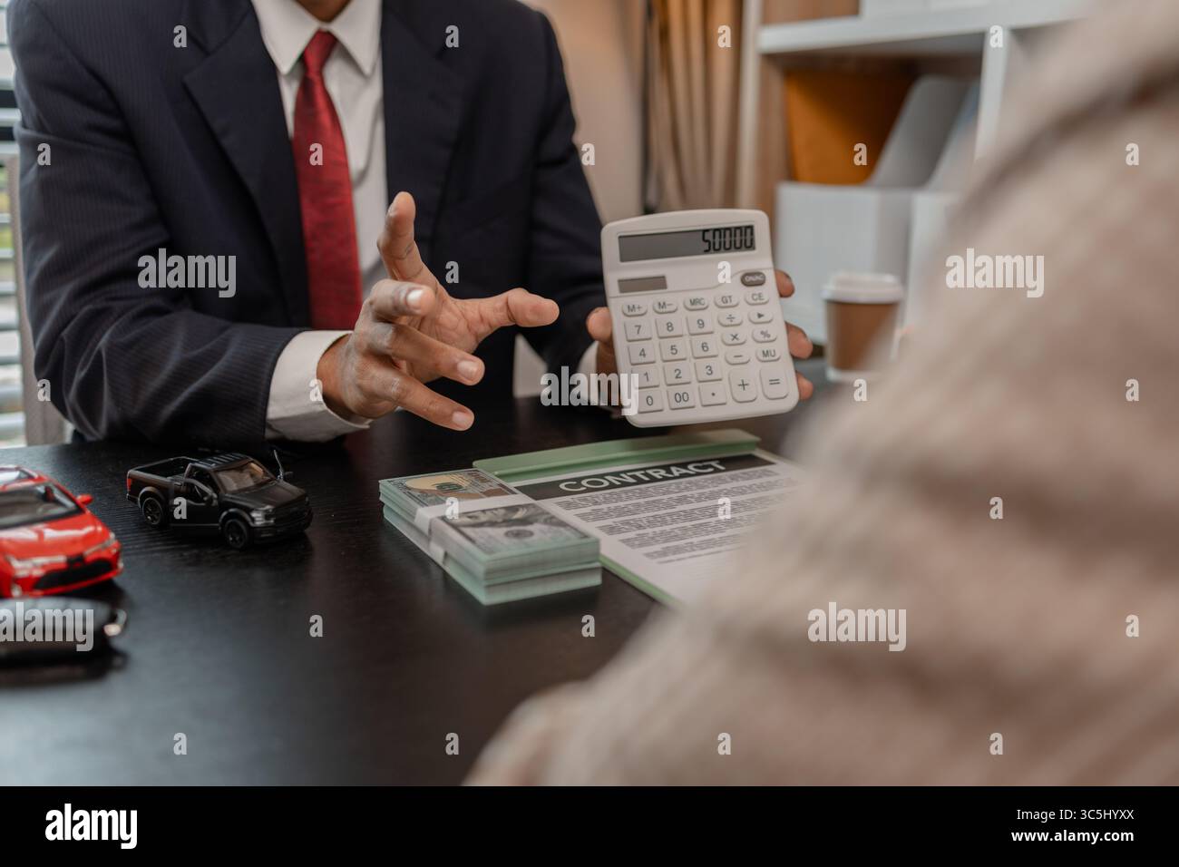 un venditore di auto sta spiegando i dettagli di una vettura e il prezzo a cui un acquirente è interessato, il responsabile vendite dello showroom ha spiegato la quantità di int Foto Stock