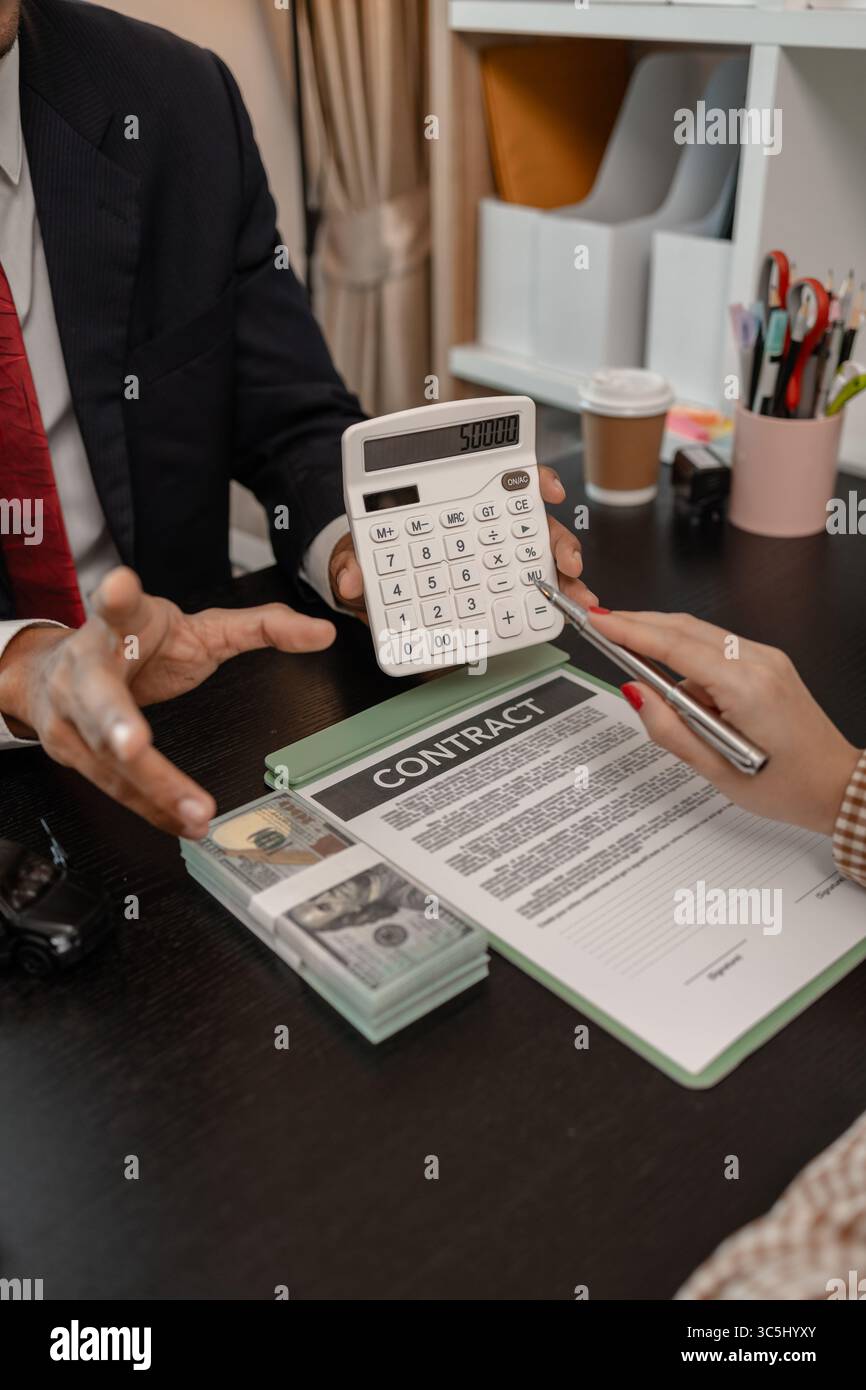 un venditore di auto sta spiegando i dettagli di una vettura e il prezzo a cui un acquirente è interessato, il responsabile vendite dello showroom ha spiegato la quantità di int Foto Stock