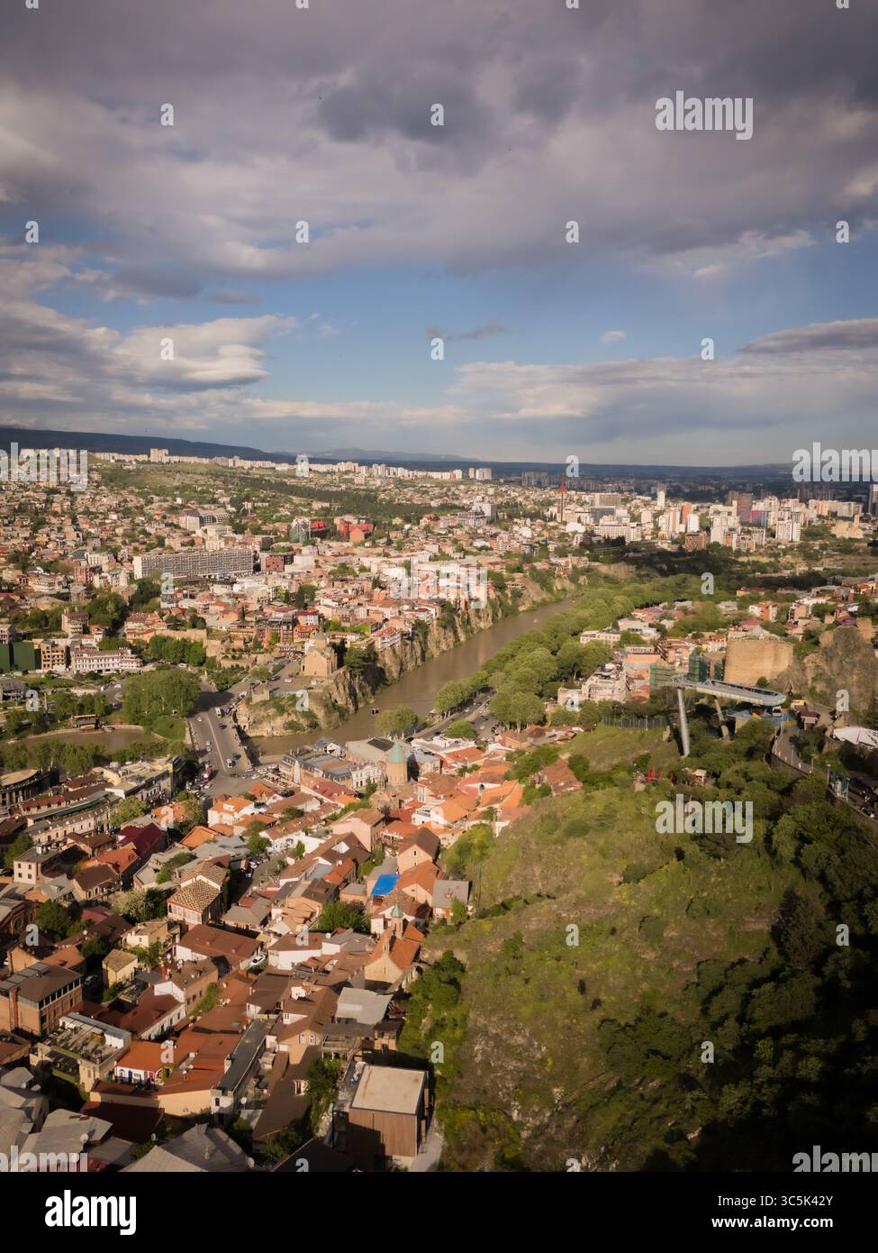 Vista aerea del tortuoso fiume Kura che attraversa il cuore della città, incorniciato dall'antica Fortezza di Narikala e dal Ponte della Pace, Tbilisi, Tbilisi, Georgia. Foto Stock