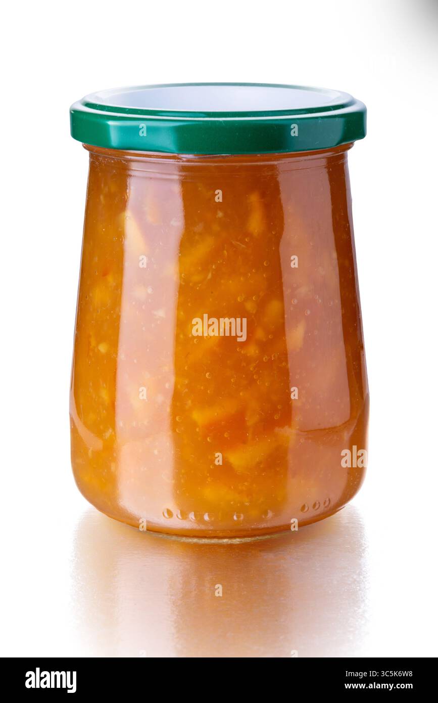 Marmellata arancione in un vaso di vetro con tappo verde isolato su bianco con percorso di ritaglio incluso Foto Stock