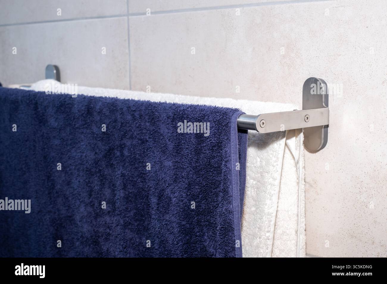 I morbidi asciugamani sono disposti in modo ordinato su un elegante portasciugamani in un bagno moderno, evidenziando un'estetica pulita e un'atmosfera invitante per il relax e. Foto Stock