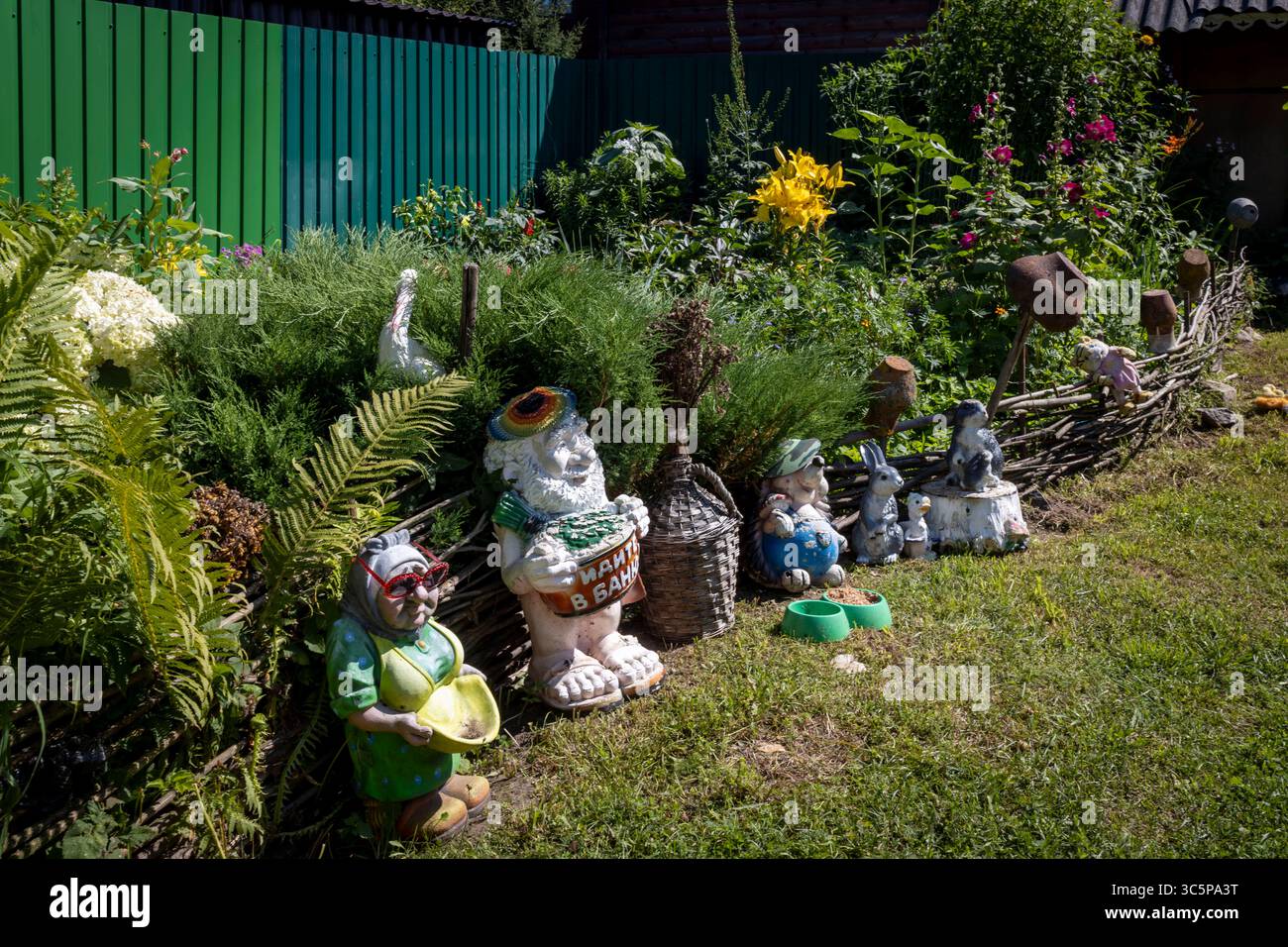 Giardino stravagante con recinto di legno Wattle e Gnome 'Go to the Bathhouse' Foto Stock