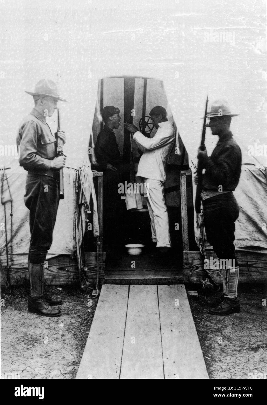 6 novembre 1918 - Dallas, Texas, USA - un medico dell'esercito spruzza la gola di un paziente come trattamento preventivo contro l'influenza durante l'epidemia di influenza spagnola del 1918. Lo spray consisteva in genere di un antisettico. La Croce Rossa americana era al Love Field di Dallas per aiutare a curare e prevenire la continua diffusione della pandemia. (Immagine di credito: © Museo Nazionale della salute/TNS/ZUMAPRESS.com) Foto Stock