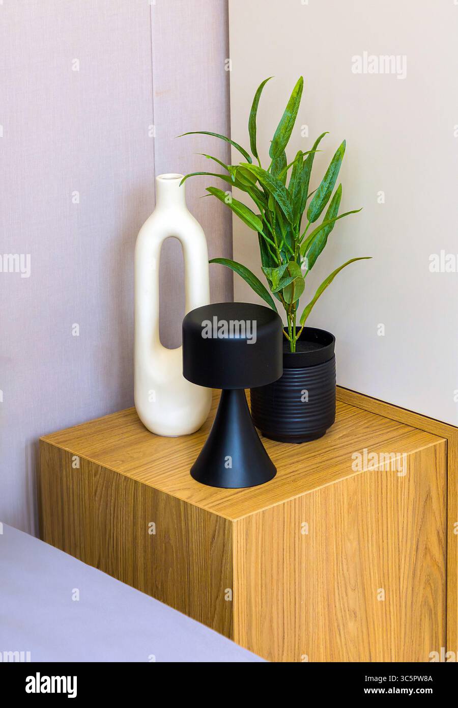 Decorazioni in ceramica e piante floreali all'interno su un tavolo da notte Foto Stock