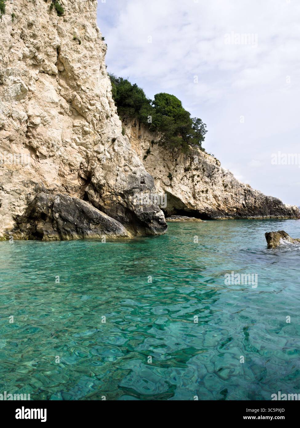Costa meridionale dell'isola di Zante, Grecia, con scogliere rocciose e acque turchesi sotto un luminoso cielo estivo ionico. Foto Stock