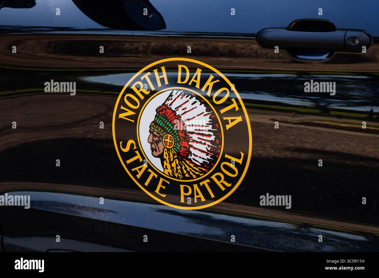 Bismarck, North Dakota, USA - 8 luglio 2025: Un'auto della polizia della North Dakota State Patrol, che mostra il suo emblema ufficiale della porta con un profilo di Red Tomah Foto Stock
