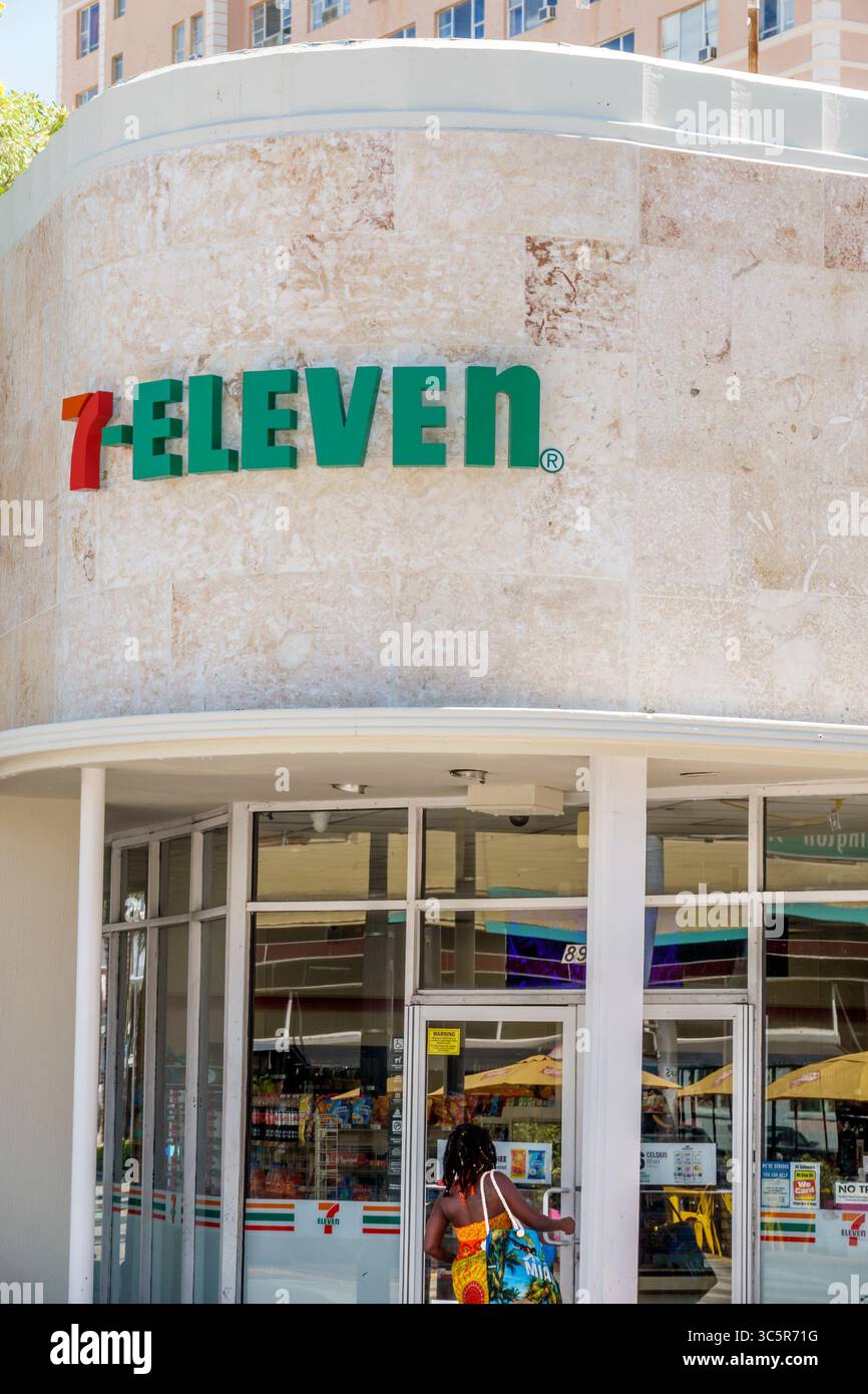 Miami Beach Florida, South Beach, Washington Avenue, ingresso al minimarket aperto 24 ore su 24 7-Eleven con logo rosso verde sopra la facciata curva in pietra abbronzata, Black African Foto Stock