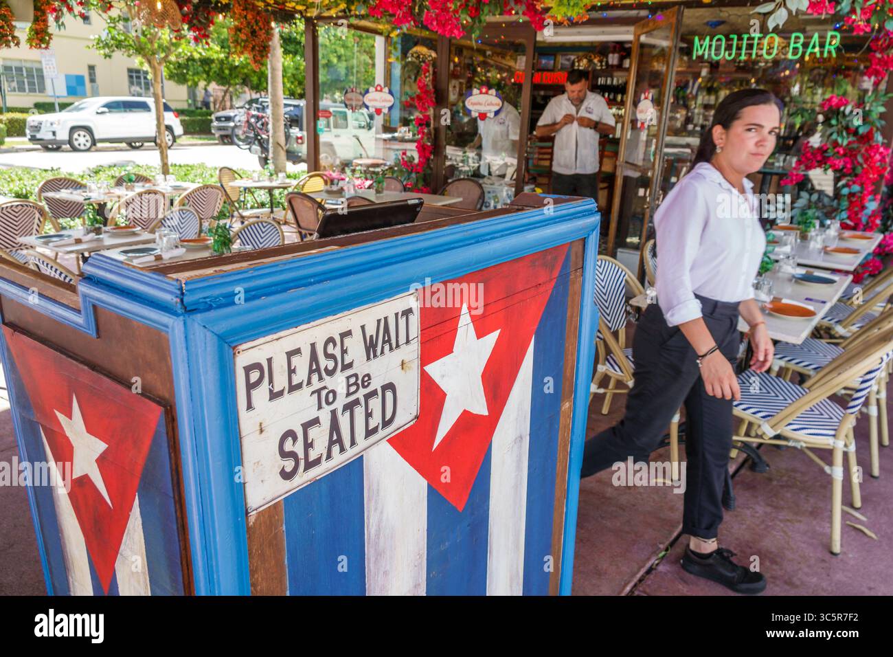 Miami Beach, Florida, South Beach, Washington Avenue, ristorante Esquina Cubana, ingresso, stand hostess con bandiera cubana, si prega di attendere di essere seduti Foto Stock