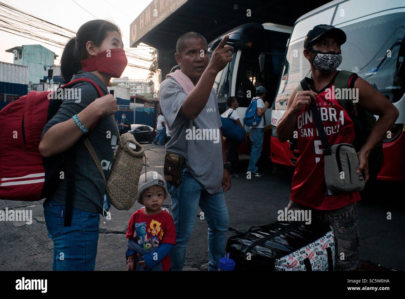13 marzo 2020 - Manila, Filippine - Lisa, Left e Jarred Torres, a destra, e il loro figlio Jayson cerca un autobus per tornare a Laguna, dato che l'ultimo autobus era pieno il 13 marzo 2020. Milioni di filippini fuggirono per le province dopo che Duterte dichiarò una quarantena limitata nella metropolitana di Manila che diede una finestra di 72 ore per la gente che lasciava la regione. (Immagine di credito: © Eli Hiller/ZUMA Wire/ZUMAPRESS.com) Foto Stock