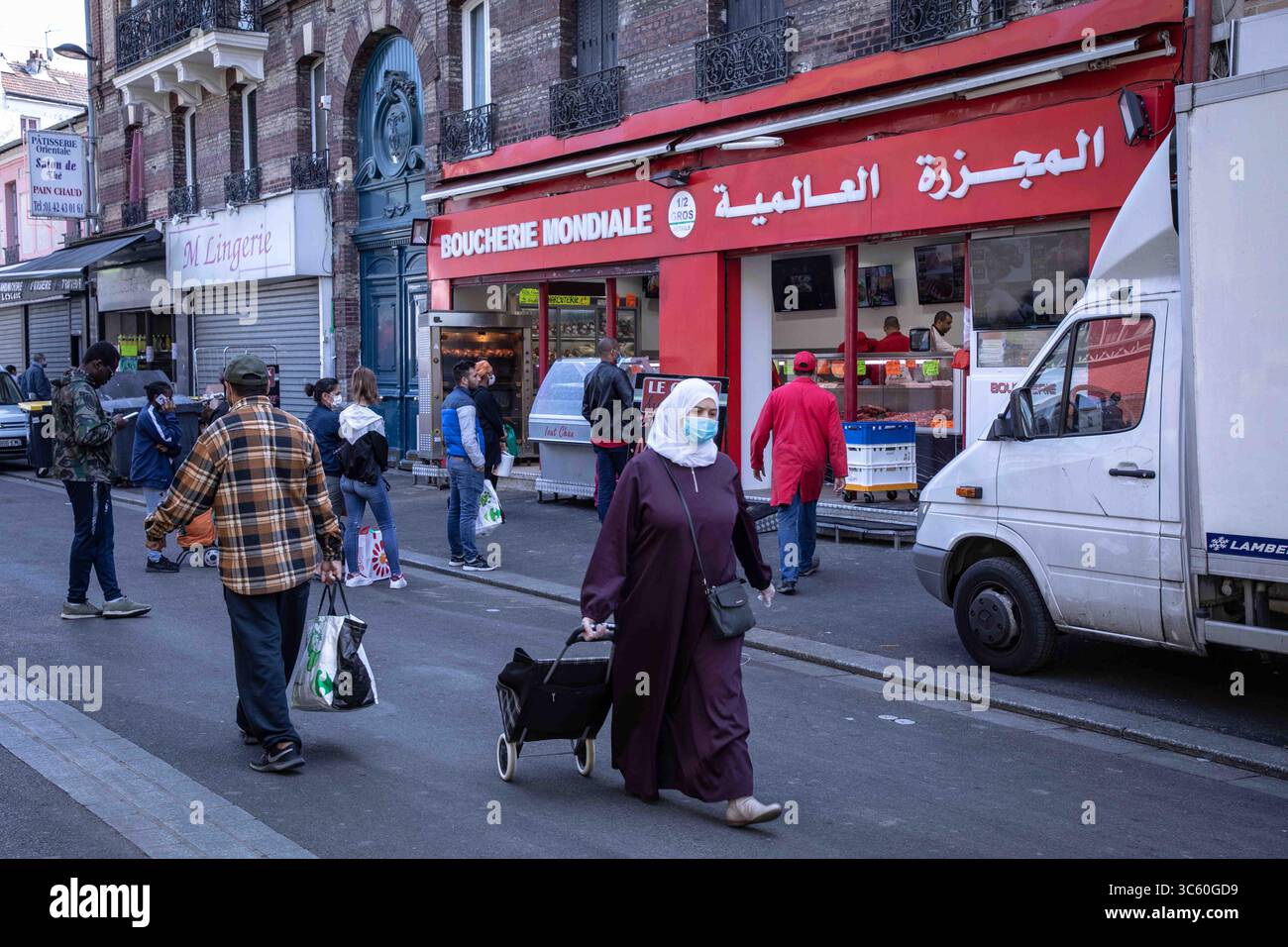 25 aprile 2020, Parigi, Francia: Una donna musulmana che indossa una maschera facciale come precauzione, tirando un carrello durante il Ramadan in mezzo alla pandemia del virus corona..a Saint Denis, un sobborgo parigino dove la popolazione è prevalentemente musulmana, le persone si allineano ai mercati e ai macellai per preparare i pasti del Ramadan in tempi della pandemia. Indossano maschere per proteggersi dal virus, ma il distanziamento sociale è ben lungi dall'essere realizzato. (Immagine di credito: © Andreina Flores/SOPA Images via ZUMA Wire) Foto Stock