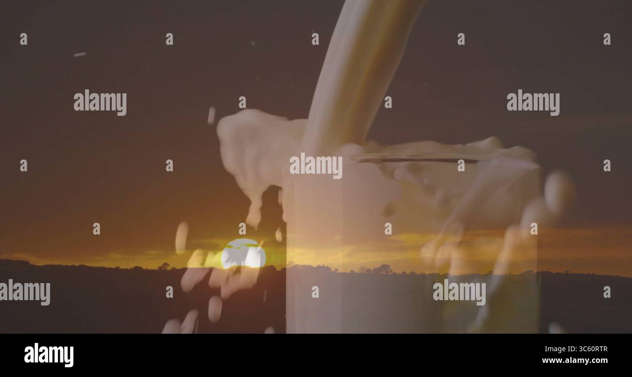 Versare il flusso di latte in vetro trasparente, la schiuma trabocca all'orizzonte rurale al tramonto con la linea degli alberi Foto Stock