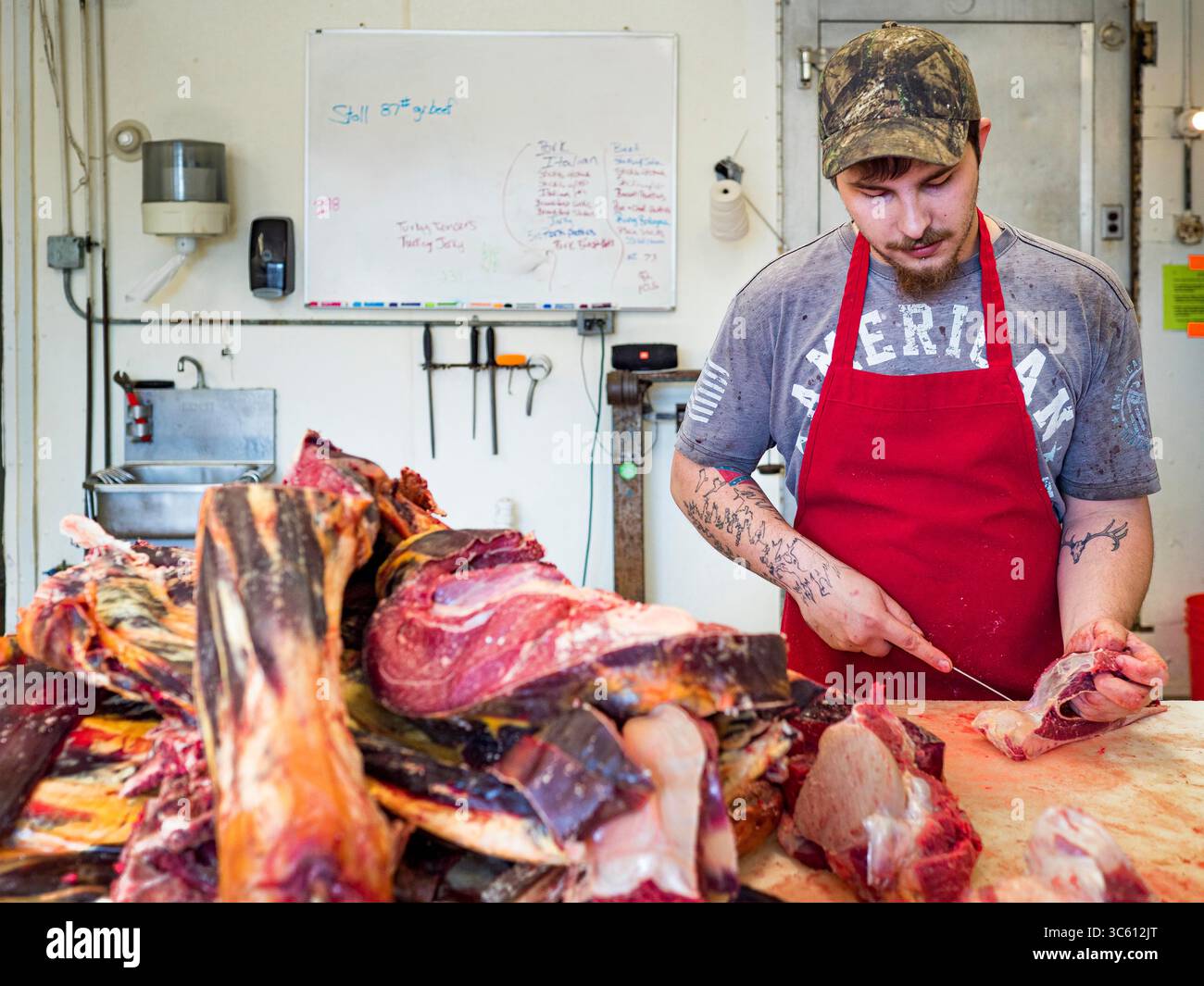 30 aprile 2020, Stanhope, Iowa, Stati Uniti: JORDAN TEEL rifinisce la carne di manzo prima di trasformarla in hamburger allo Stanhope Locker and Market, a Stanhope, Iowa. La famiglia possedeva un armadietto per macellare e macellare bovini, suini e ovini. La pandemia di COVID-19 (SARS-CoV-2/Coronavirus) si è diffusa tra i dipendenti degli stabilimenti di confezionamento della carne in Iowa, Nebraska, South Dakota e Minnesota, costringendo molti a chiudere o ridurre le operazioni. Ciò ha portato gli agricoltori a eutanasia di migliaia di suini e bovini da carne. La produzione di maiale è stata tagliata di circa il 40% a causa della pandemia. Armadietti per la carne e a conduzione familiare Foto Stock