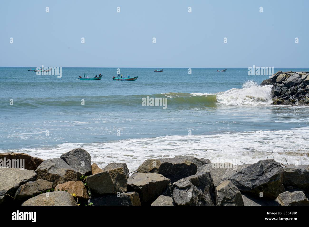 Vista sulla spiaggia con rocce e barche da pesca nel mare. Foto Stock