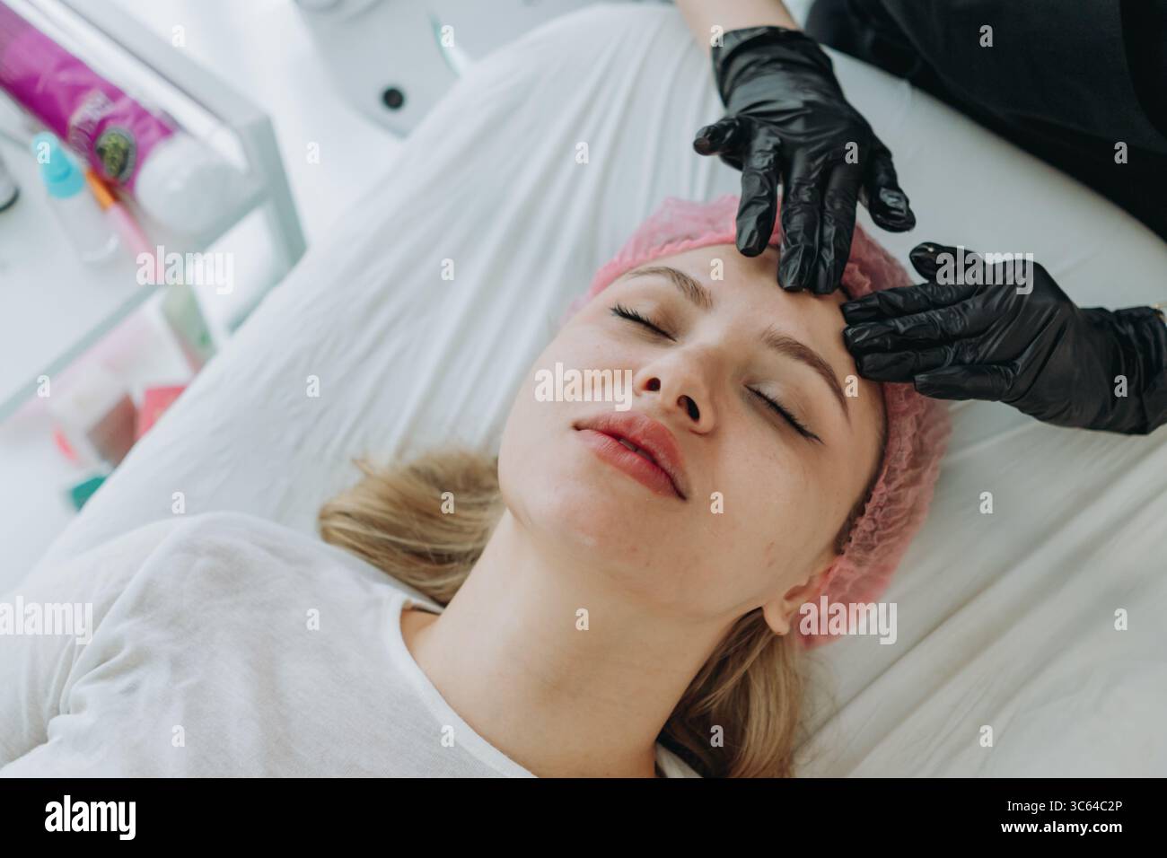 giovane donna ottenere massaggio viso professionale presso la clinica estetica Foto Stock