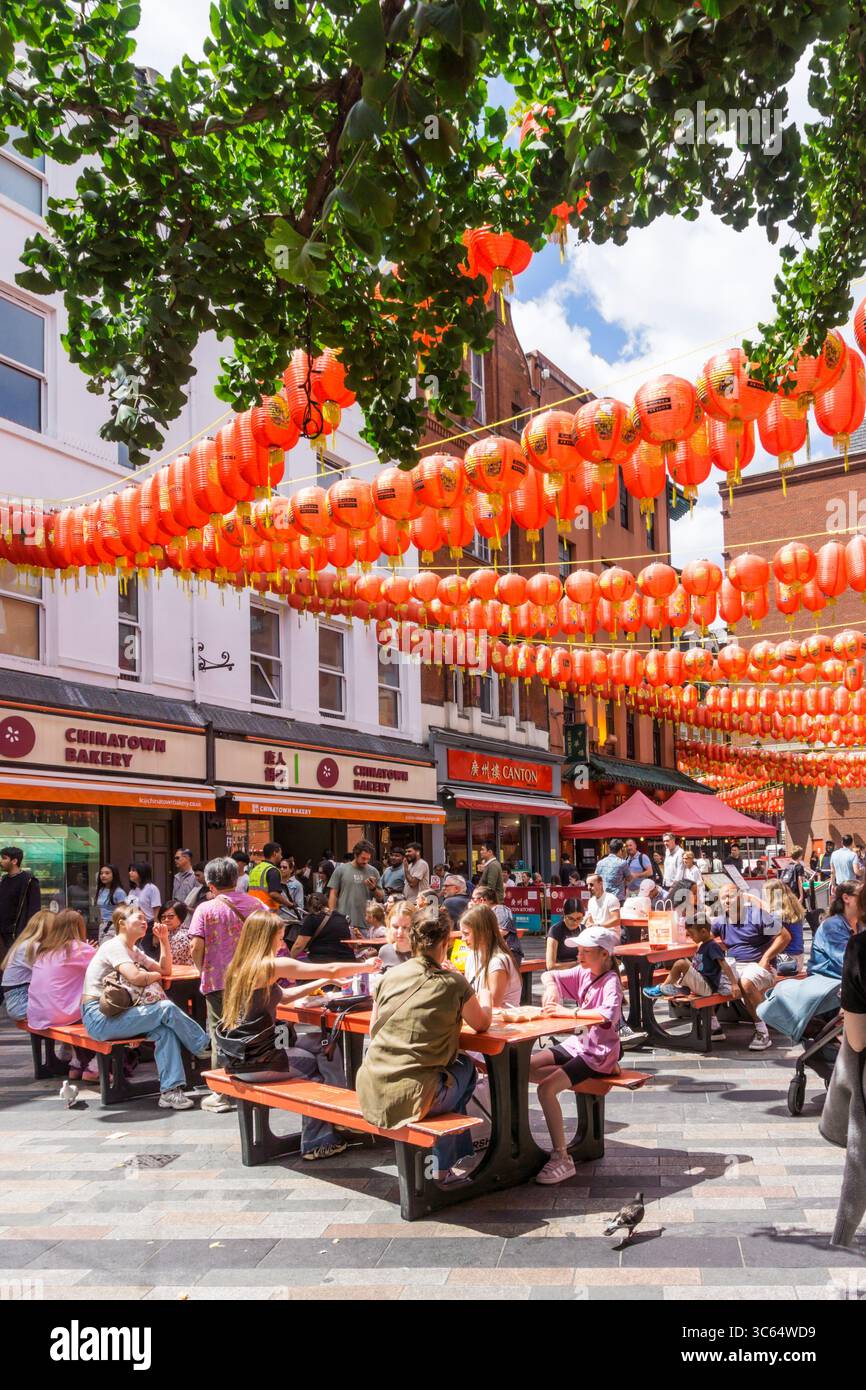 Gente che mangia fuori sotto le lanterne cinesi a Newport Place, Soho. Foto Stock